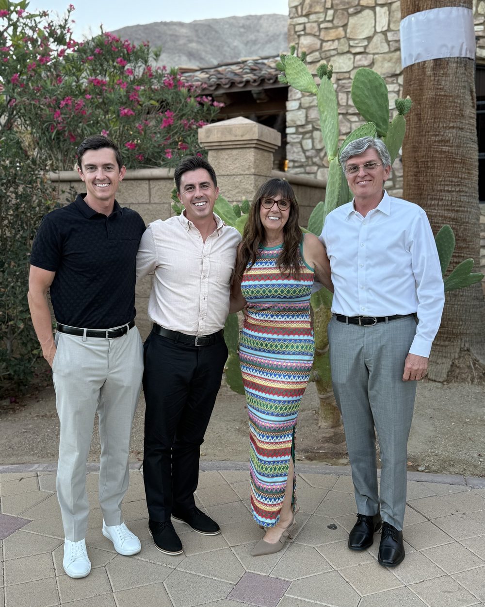 Brennan with his family outside a stone house in the desert.
